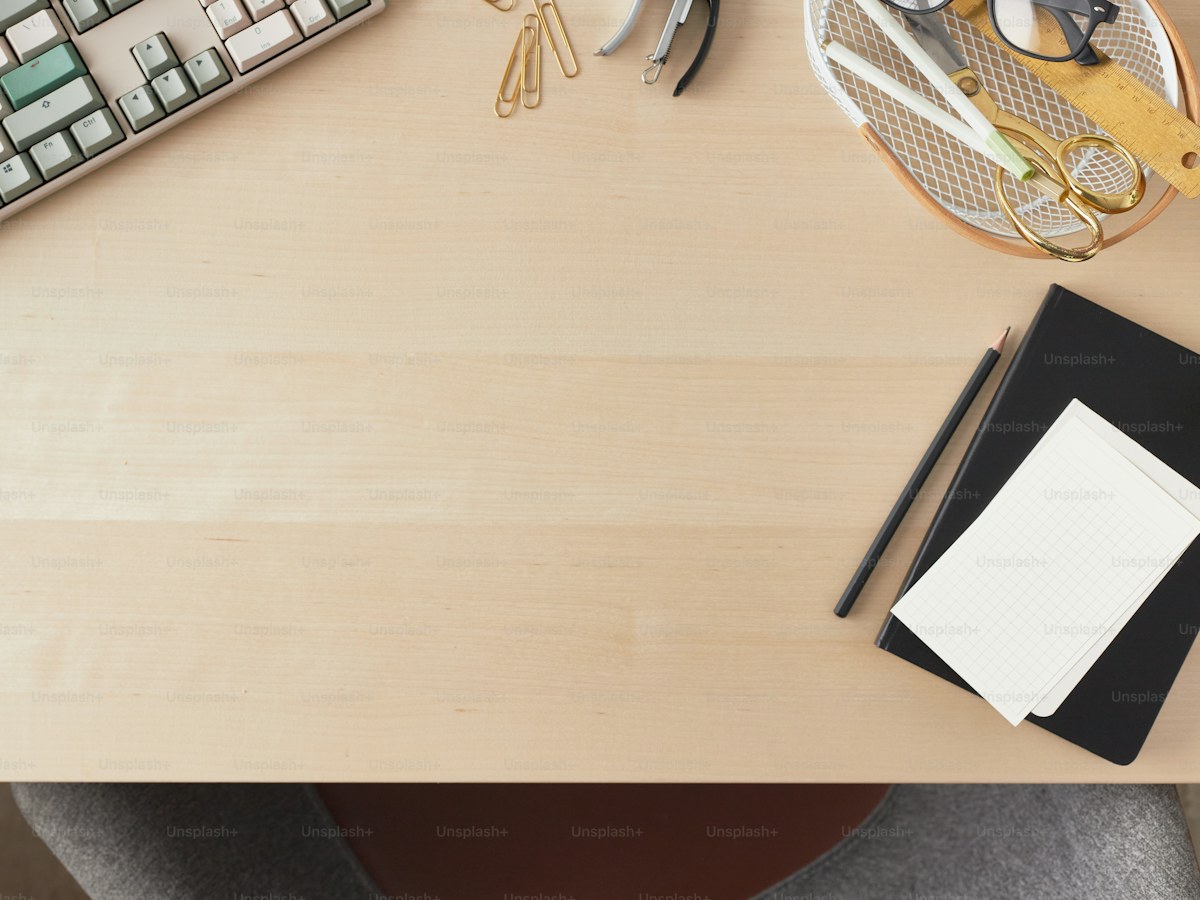 a desk with a keyboard, a mouse, and a notebook