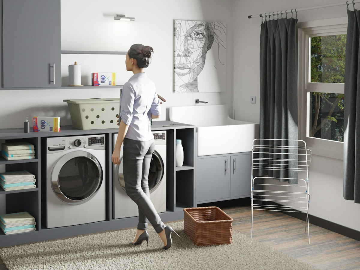 a woman standing in a laundry room next to a washer and dryer